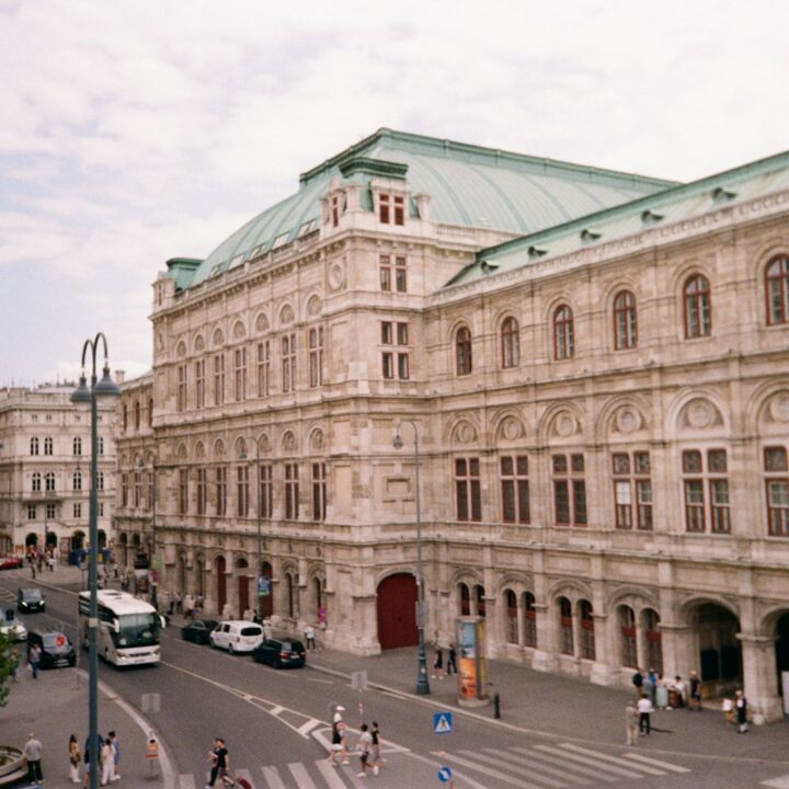 A large building with a green roof next to a street