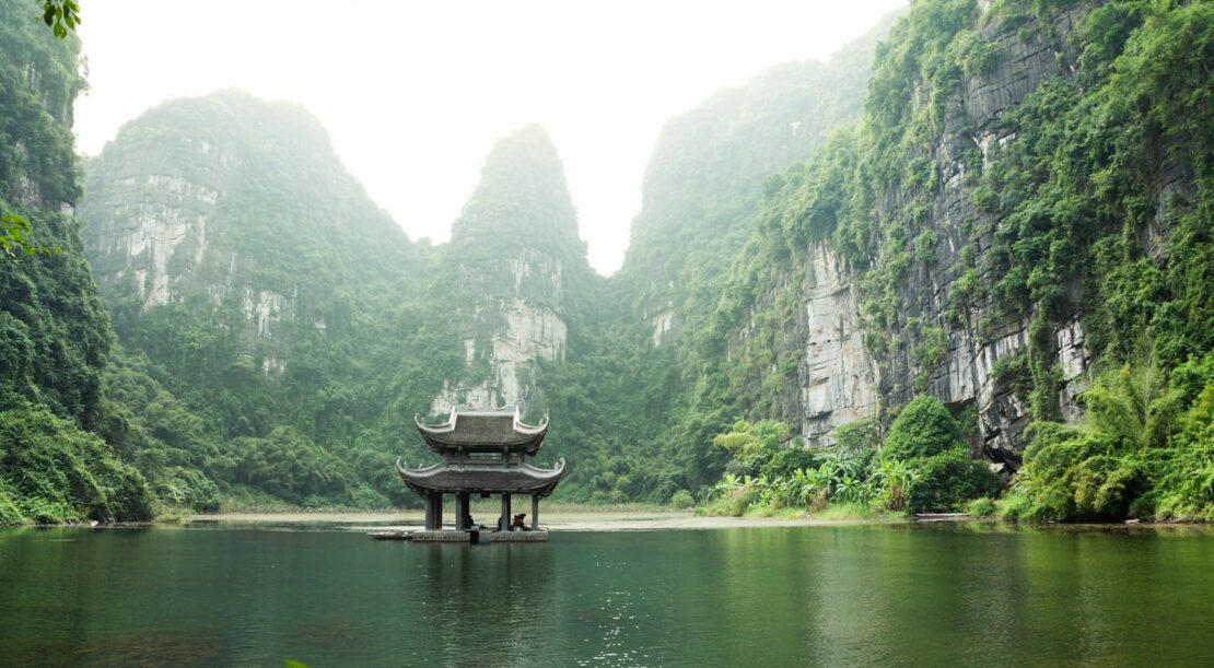 pagoda surrounded by body of water and mountains