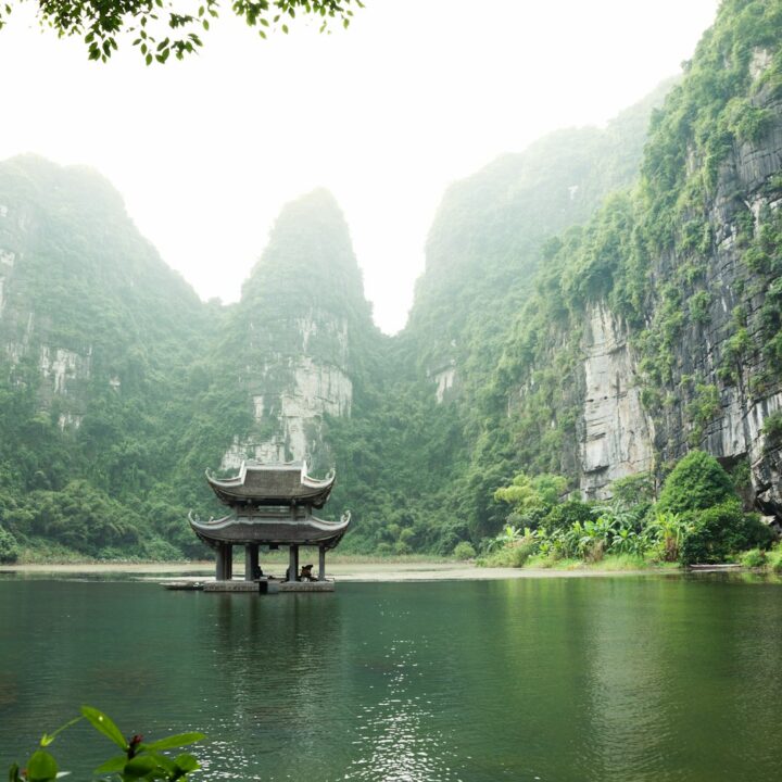 pagoda surrounded by body of water and mountains