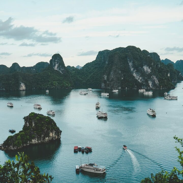 high-angle photography of boats on water near hill during daytime