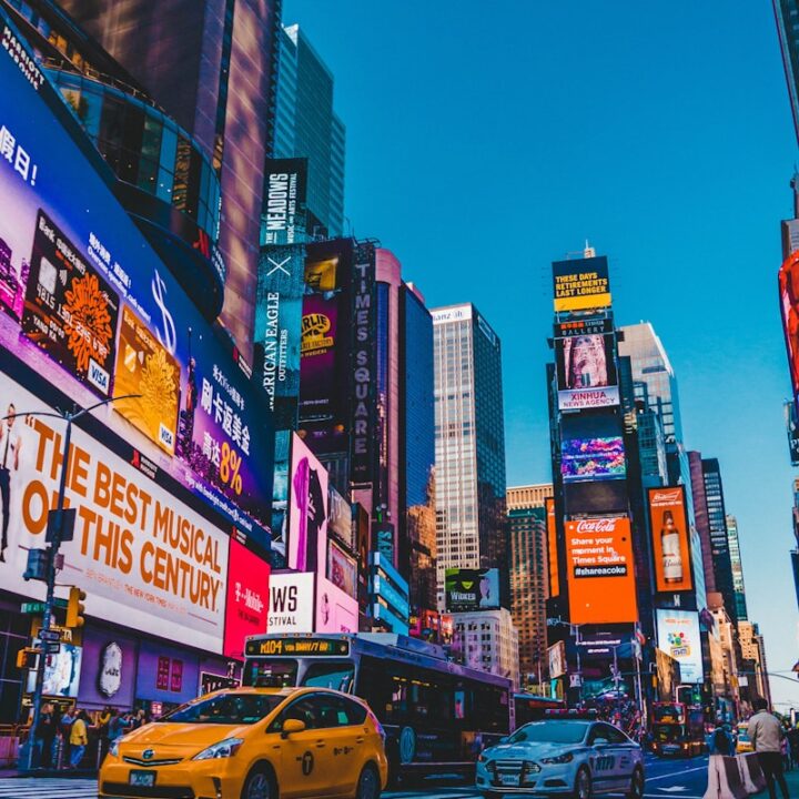 cars parked on street near high rise buildings during night time
