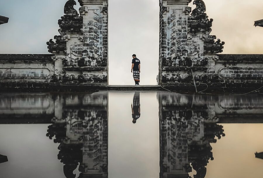 man standing between ruins in reflective photography